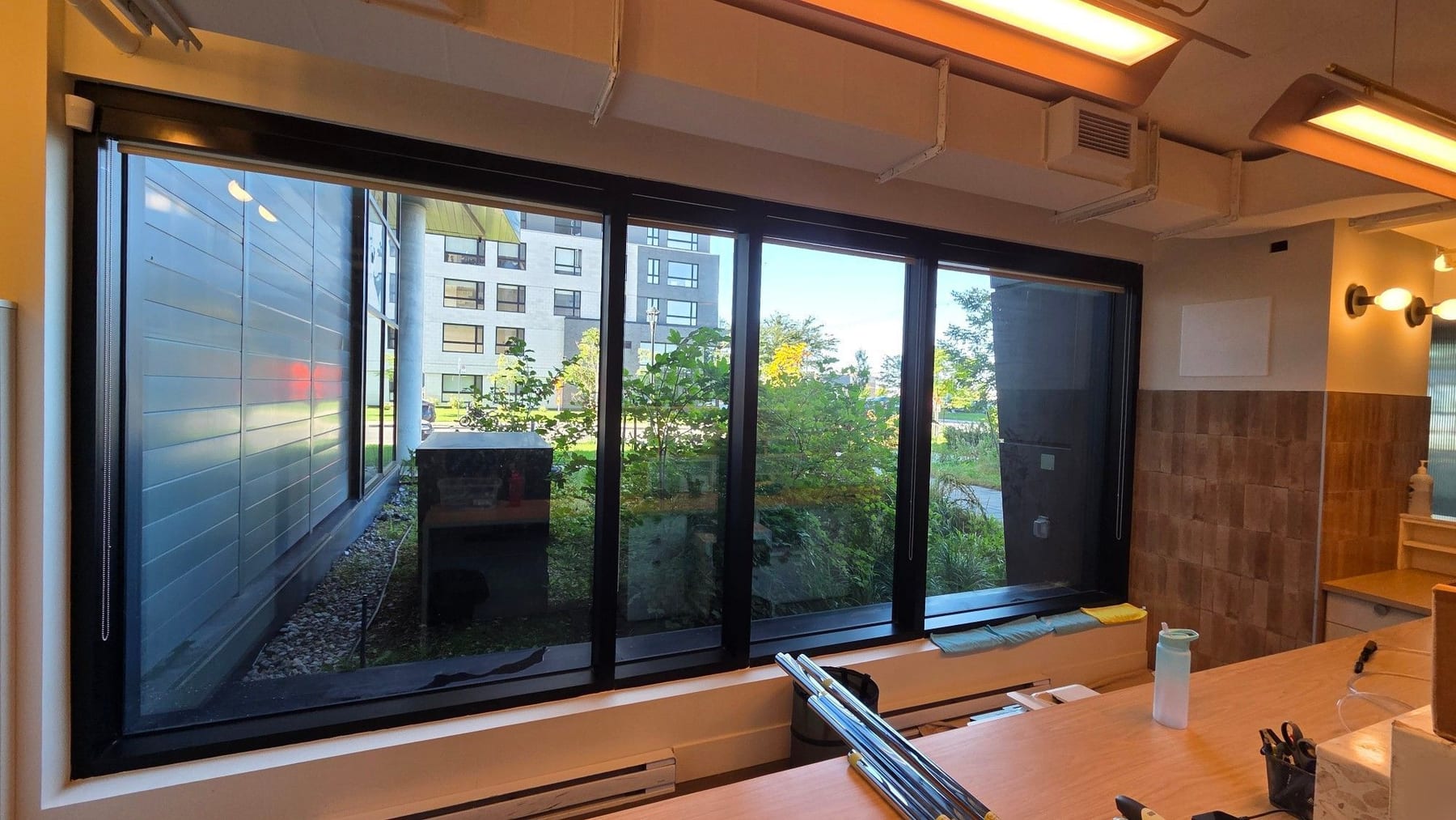 Grande fenêtre d'un espace de travail de la clinique, vue de l'intérieur, avec store partiellement relevé