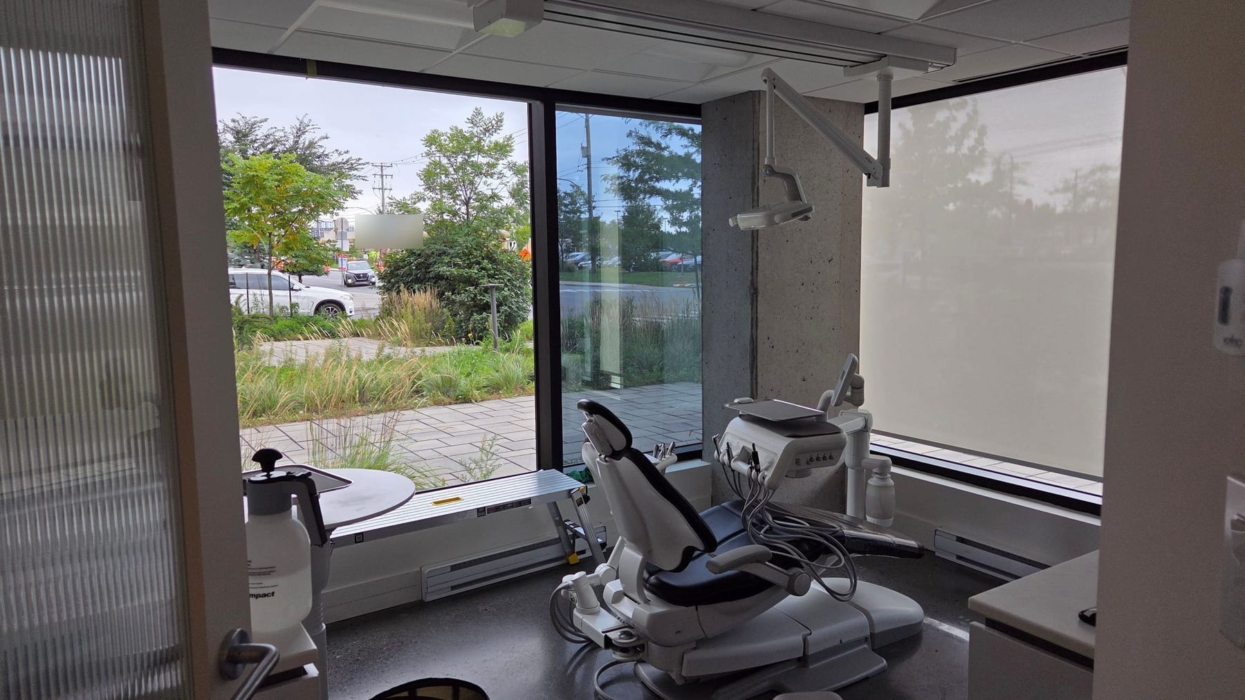 Salle de traitement : dans le coin de fenêtres, une vitre sans pellicule laisse voir la rue nettement tandis que la vitre voisine, avec pellicule, renvoie un reflet