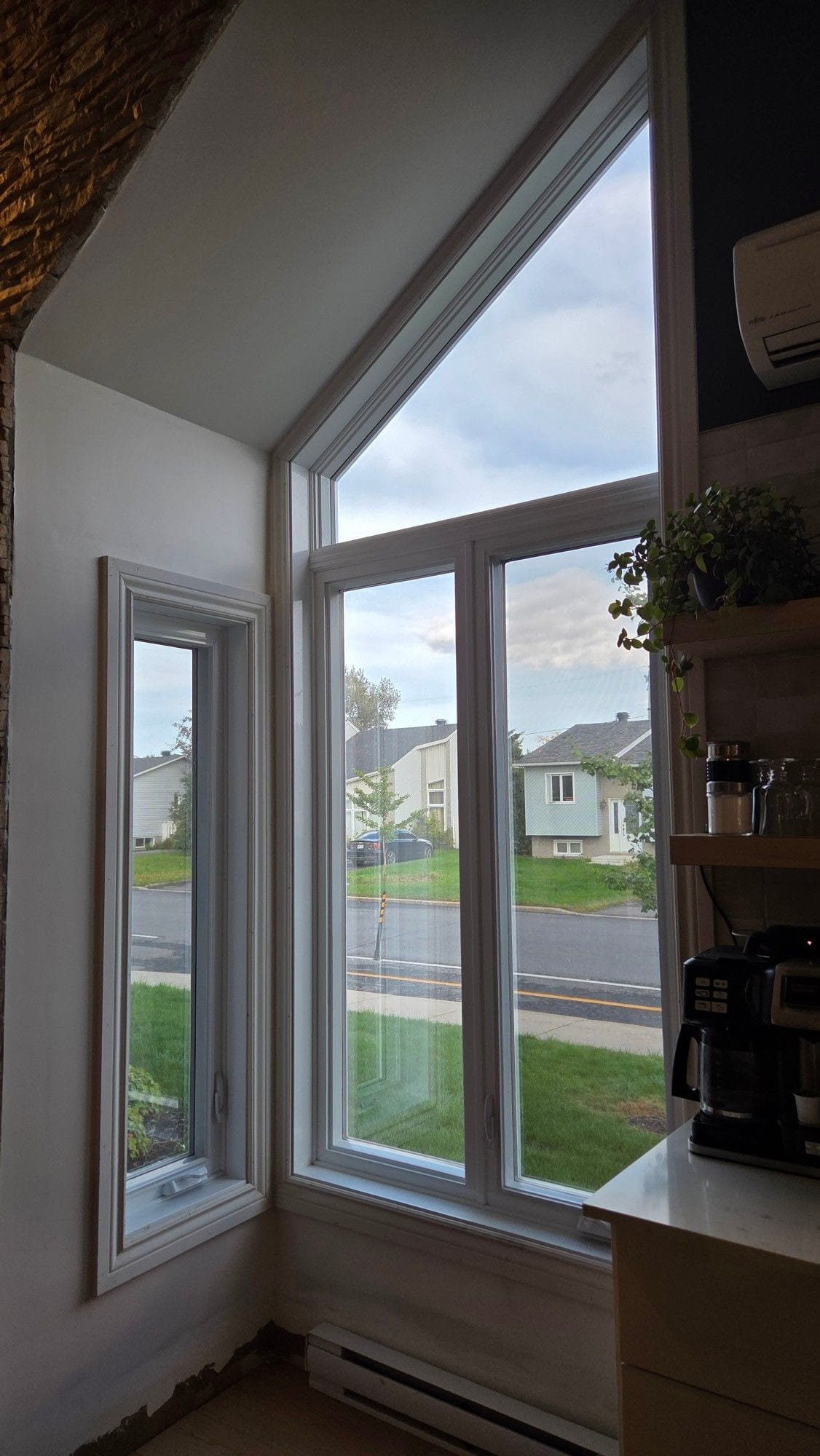 La même fenêtre à sommet triangulaire vue de l’intérieur après la pellicule, avec une vue dégagée sur la rue